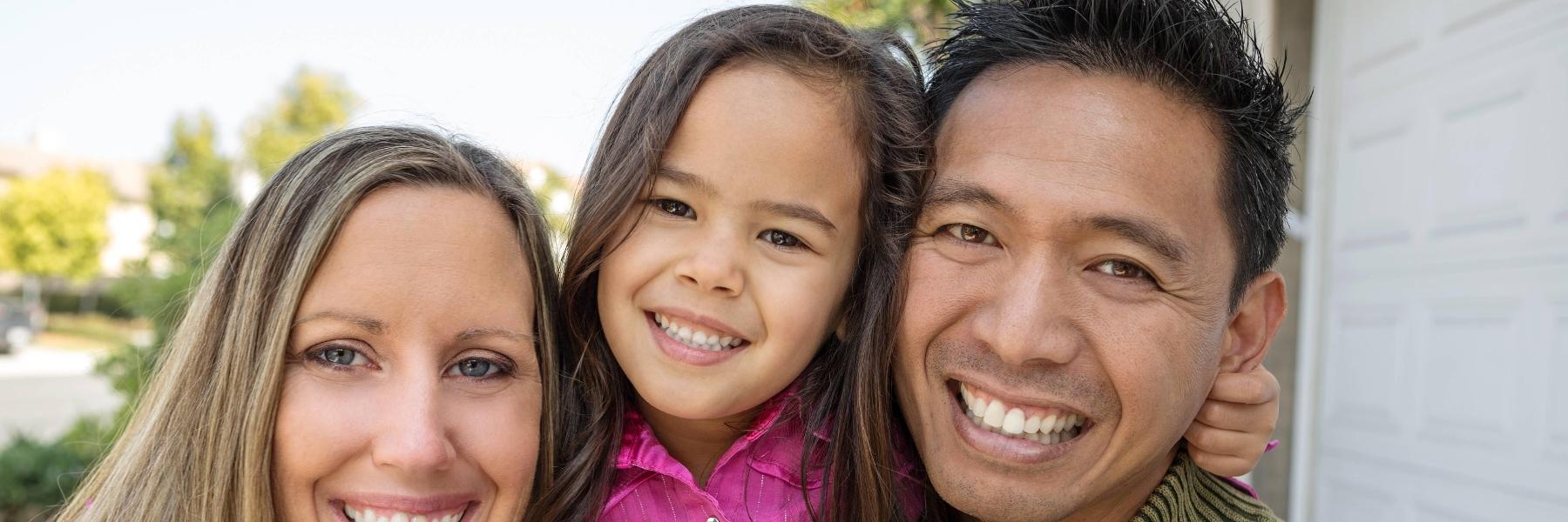 Family of three smiling at their home in Bellevue NE
