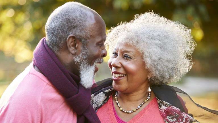 Happy older couple in sunny park.