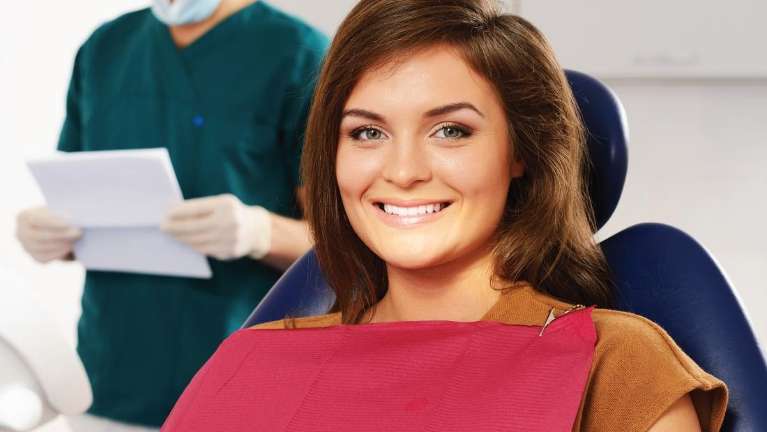 Woman smiling in treatment chair at gum disease dentist in Bellevue, NE