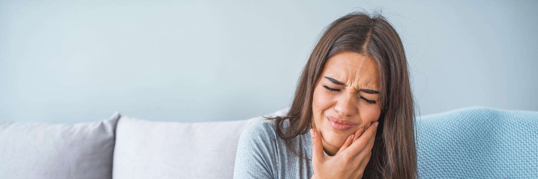 Woman experiencing tooth pain, highlighting signs that may require a root canal in Bellevue, NE.